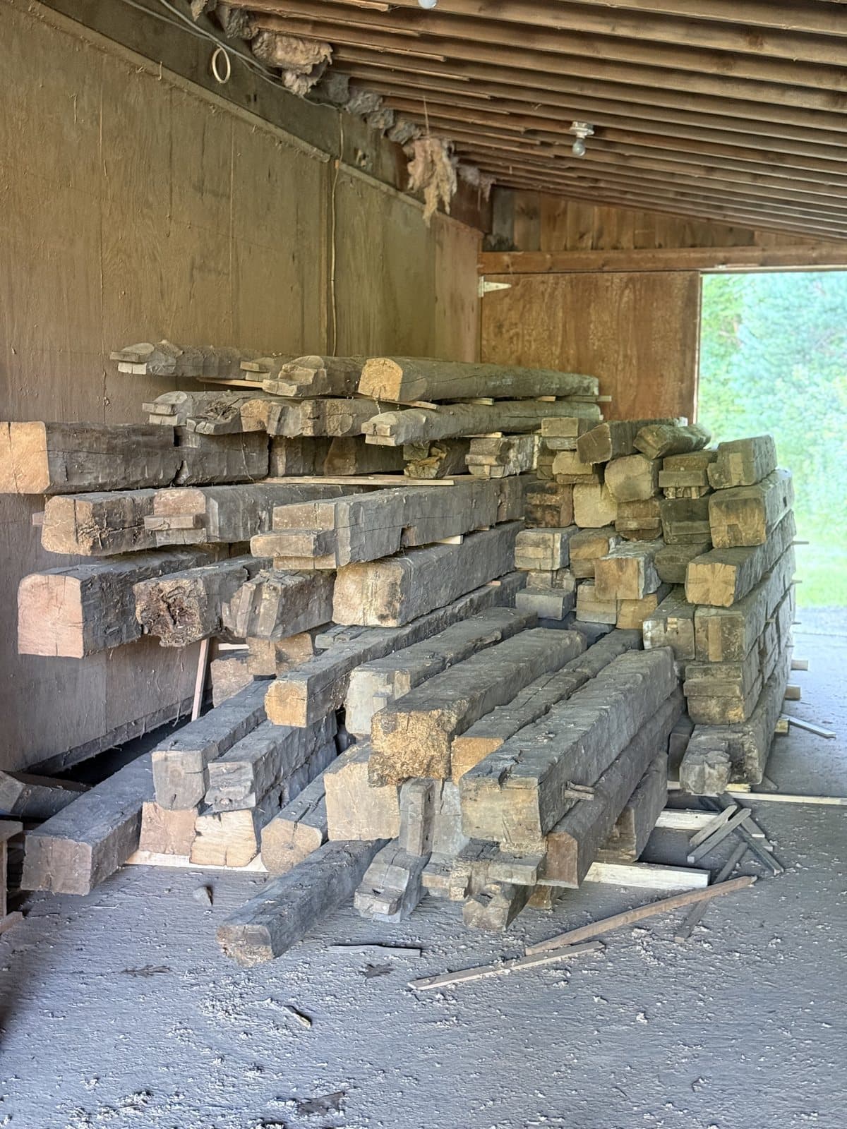 A stack of hand hewn barn beams inside the shop