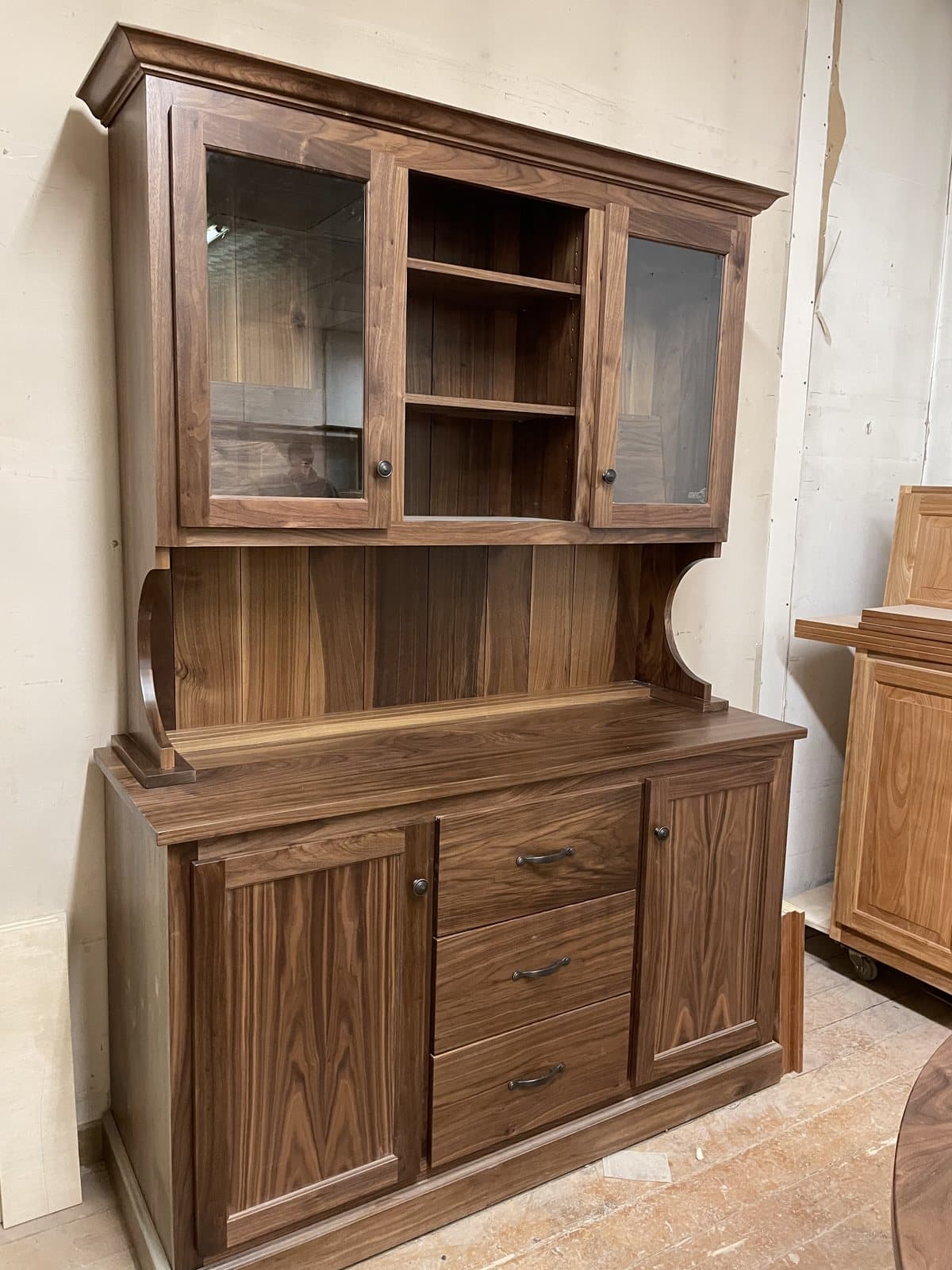 Walnut hutch with glass doors and a paneled base